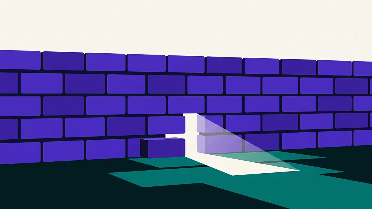 a solid wall with a single brick missing at ground level, revealing bright light streaming through the gap